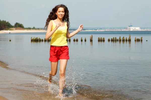 在夏天在沙滩上散步的年轻女子 — 图库照片