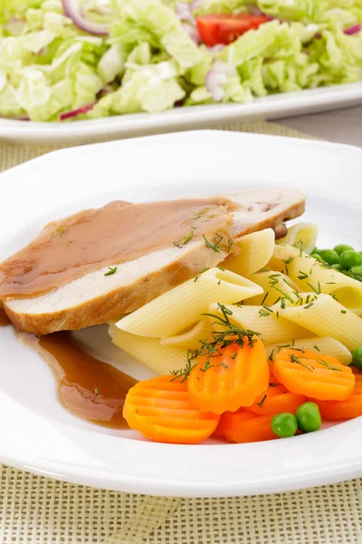 Roasted pork shoulder served with pasta and vegetables — Stock Photo, Image