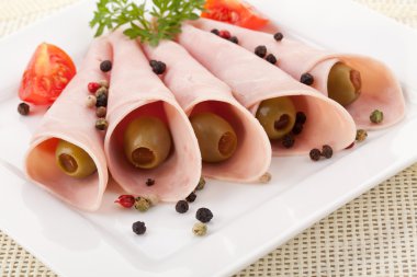 bir tabakta yeşil zeytin ile pişmiş jambon