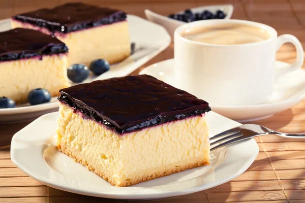 Tarta de queso con arándanos y una tapa de café —  Fotos de Stock