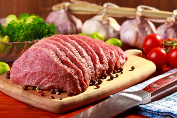 Carne de bovino em bruto e produtos hortícolas sobre madeira — Fotografia de Stock