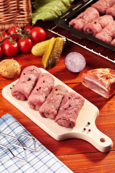 Raw beef rolls on a wooden board — Stock Photo, Image