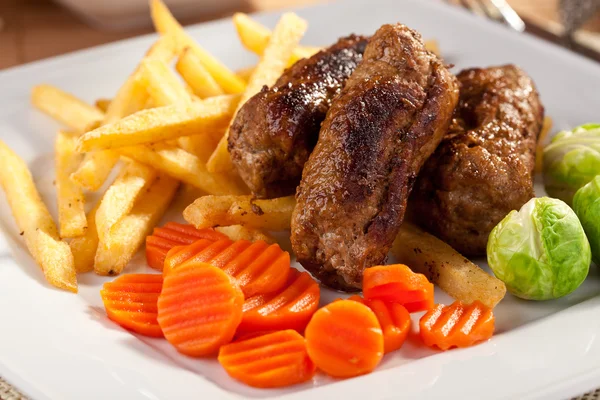 Roast beef rolls with chips and vegetables — Stock Photo, Image