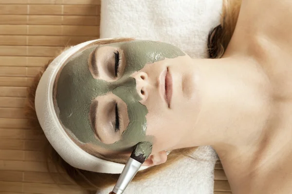 Beautiful girl having clay body mask. — Stock Photo, Image