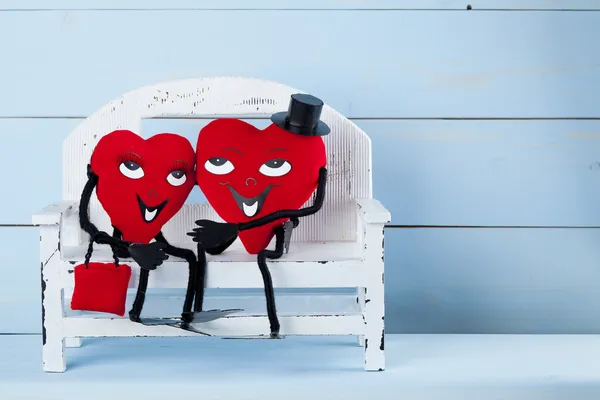 Zwei verliebte Herzen auf einer Bank. — Stockfoto