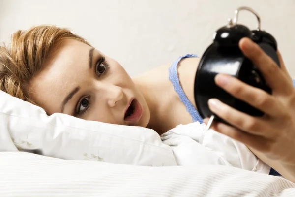 Beautiful young woman sleeping on bed with alarm clock — Stock Photo, Image