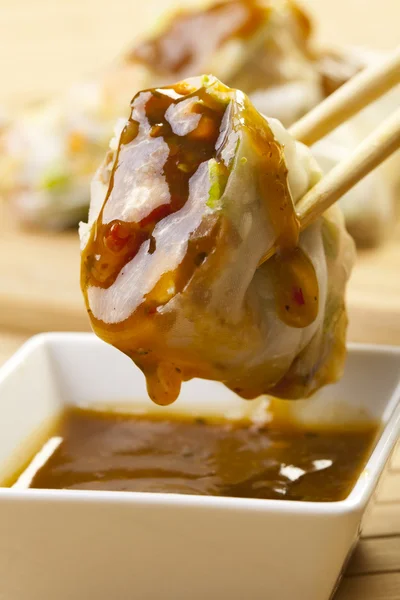 The spring roll dipped in a sauce — Stock Photo, Image