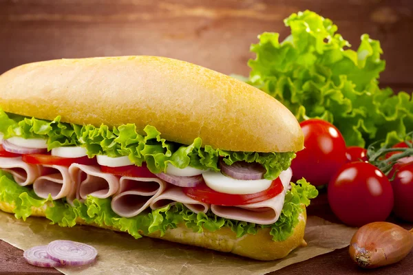 Stor smörgås med skinka, ost och grönsaker — Stockfoto