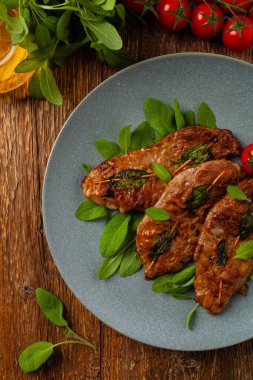 Saltimbocca. Adaçayı ve Parma jambonlu dana şnitzel. İtalyan spesiyali. Üst görünüm.