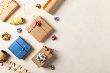 Hediye paketi. Paketleme aksesuarları ve hediyelerle dolu parlak bir arka plan. Yaratıcı kompozisyon. Tarif için yer. Üst görünüm.