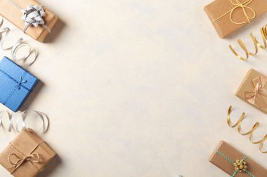 Hediye paketi. Paketleme aksesuarları ve hediyelerle dolu parlak bir arka plan. Yaratıcı kompozisyon. Tarif için yer. Üst görünüm.