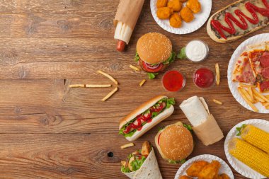 Fast food ve sokak yemekleri karışımı. Kopya alanı olan bir arkaplan. Üst Manzara. Doğal ahşap zemin. 