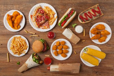 Fast food ve sokak yemekleri karışımı. Kopya alanı olan bir arkaplan. Üst Manzara. Doğal ahşap zemin. 