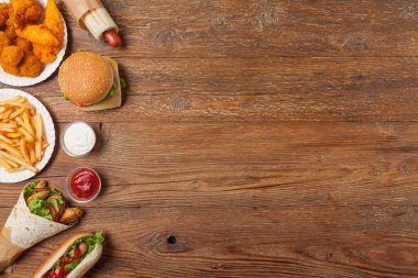 Fast food ve sokak yemekleri karışımı. Kopya alanı olan bir arkaplan. Üst Manzara. Doğal ahşap zemin. 