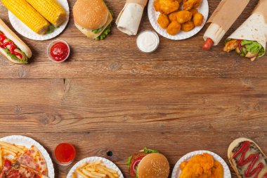 Fast food ve sokak yemekleri karışımı. Kopya alanı olan bir arkaplan. Üst Manzara. Doğal ahşap zemin. 