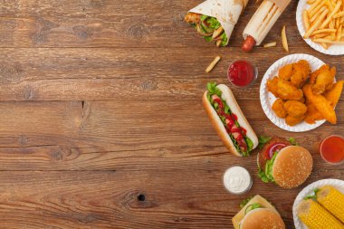 Fast food ve sokak yemekleri karışımı. Kopya alanı olan bir arkaplan. Üst Manzara. Doğal ahşap zemin. 