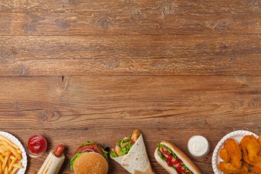 Fast food ve sokak yemekleri karışımı. Kopya alanı olan bir arkaplan. Üst Manzara. Doğal ahşap zemin. 