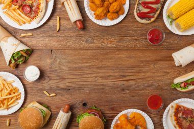 Fast food ve sokak yemekleri karışımı. Kopya alanı olan bir arkaplan. Üst Manzara. Doğal ahşap zemin. 