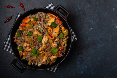 Siyah susamlı buğday eriştesi, tavuk ve sebzeli tavada kızartılmış. Üst görünüm.