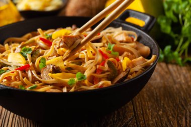 Mangolu kızarmış tavuk ve erişteli hindistan cevizi sütü. Bir tavada hazır. Ön görünüm. 