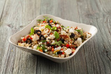 Kırmızı pirinçli moda öğle yemeği, sebze ve sebze karışımı. Ön manzara. Gri ahşap arka planda beyaz kasede servis ediliyor.. 