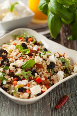 Kırmızı pirinçli moda öğle yemeği, sebze ve sebze karışımı. Ön manzara. Gri ahşap arka planda beyaz kasede servis ediliyor.. 