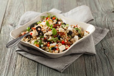 Kırmızı pirinçli moda öğle yemeği, sebze ve sebze karışımı. Ön manzara. Gri ahşap arka planda beyaz kasede servis ediliyor.. 