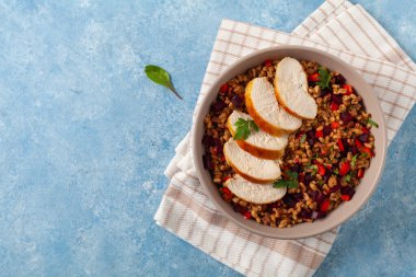 Mısır gevreği, pancar kökü ve tavukla moda bir öğle yemeği. Mavi boyalı arka planda bir kasede servis edilmiş. Üst görünüm. 