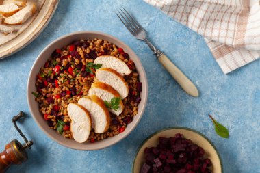 Mısır gevreği, pancar kökü ve tavukla moda bir öğle yemeği. Mavi boyalı arka planda bir kasede servis edilmiş. Üst görünüm. 