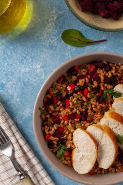 Mısır gevreği, pancar kökü ve tavukla moda bir öğle yemeği. Mavi boyalı arka planda bir kasede servis edilmiş. Üst görünüm. 