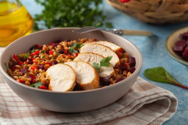 Mısır gevreği, pancar kökü ve tavukla moda bir öğle yemeği. Mavi boyalı arka planda bir kasede servis edilmiş. Ön görünüm. 