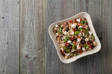 Kırmızı pirinçli moda öğle yemeği, sebze ve sebze karışımı. Üst Manzara. Gri ahşap arka planda beyaz kasede servis ediliyor.. 