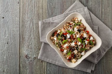 Kırmızı pirinçli moda öğle yemeği, sebze ve sebze karışımı. Üst Manzara. Gri ahşap arka planda beyaz kasede servis ediliyor.. 