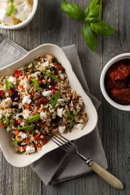 Kırmızı pirinçli moda öğle yemeği, sebze ve sebze karışımı. Üst Manzara. Gri ahşap arka planda beyaz kasede servis ediliyor.. 