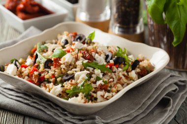 Kırmızı pirinçli moda öğle yemeği, sebze ve sebze karışımı. Ön manzara. Gri ahşap arka planda beyaz kasede servis ediliyor.. 