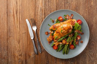 Kızarmış tavuk göğsü, kuşkonmazla servis edilen domates sosu, kurutulmuş domates. Üst görünüm.