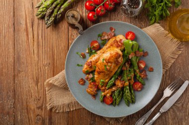 Kızarmış tavuk göğsü, kuşkonmazla servis edilen domates sosu, kurutulmuş domates. Üst görünüm.