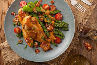 Kızarmış tavuk göğsü, kuşkonmazla servis edilen domates sosu, kurutulmuş domates. Üst görünüm.