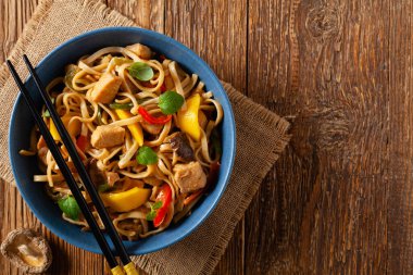 Mangolu kızarmış tavuk ve erişteli hindistan cevizi sütü. Bir tavada hazır. Üst Manzara. Mavi bir kasede servis edildi..