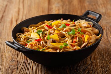 Mangolu kızarmış tavuk ve erişteli hindistan cevizi sütü. Bir tavada hazır. Ön görünüm. 