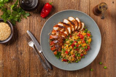 Teriyaki soslu ızgara tavuk göğsü. Kahverengi pirinç ve sebzelerle servis edilir. Üst Manzara. Düz yatıyordu.