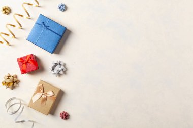 Hediye paketi. Paketleme aksesuarları ve hediyelerle dolu parlak bir arka plan. Yaratıcı kompozisyon. Tarif için yer. Üst görünüm.