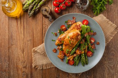 Kızarmış tavuk göğsü, kuşkonmazla servis edilen domates sosu, kurutulmuş domates. Üst görünüm.