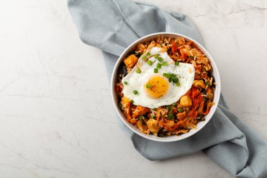 Pirinç ve tavuklu kimçi lahanası. Hafif mermer arka planda beyaz bir kasede servis edilmiş. Üst görünüm.