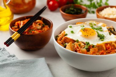 Pirinç ve tavuklu kimçi lahanası. Hafif mermer arka planda beyaz bir kasede servis edilmiş. Ön görünüm.