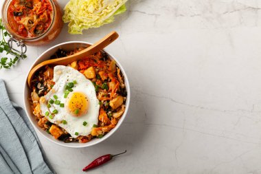 Pirinç ve tavuklu kimçi lahanası. Hafif mermer arka planda beyaz bir kasede servis edilmiş. Üst görünüm.