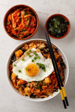 Pirinç ve tavuklu kimçi lahanası. Hafif mermer arka planda beyaz bir kasede servis edilmiş. Üst görünüm.