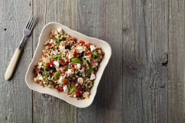 Kırmızı pirinçli moda öğle yemeği, sebze ve sebze karışımı. Üst Manzara. Gri ahşap arka planda beyaz kasede servis ediliyor.. 