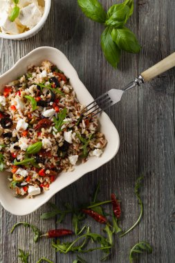 Kırmızı pirinçli moda öğle yemeği, sebze ve sebze karışımı. Üst Manzara. Gri ahşap arka planda beyaz kasede servis ediliyor.. 