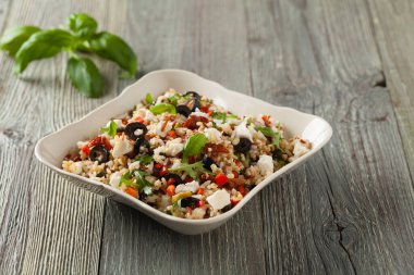 Kırmızı pirinçli moda öğle yemeği, sebze ve sebze karışımı. Ön manzara. Gri ahşap arka planda beyaz kasede servis ediliyor.. 